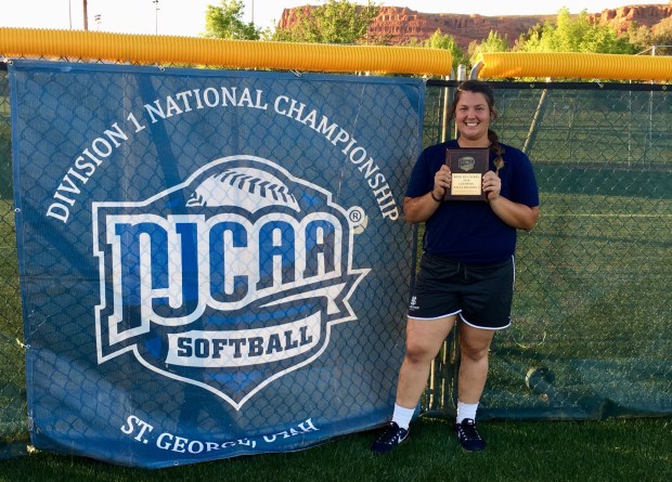 Charlee West, Softball Home Run Derby Champion posing with award/plague standing in front of a banner which reads NJCAA Softball Division 1 National Championship, St. George, Utah