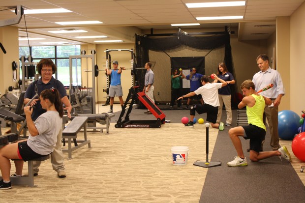 Physical Therapists and Staff working with patients and athletes in the gym area of East Lake Physical Therapy