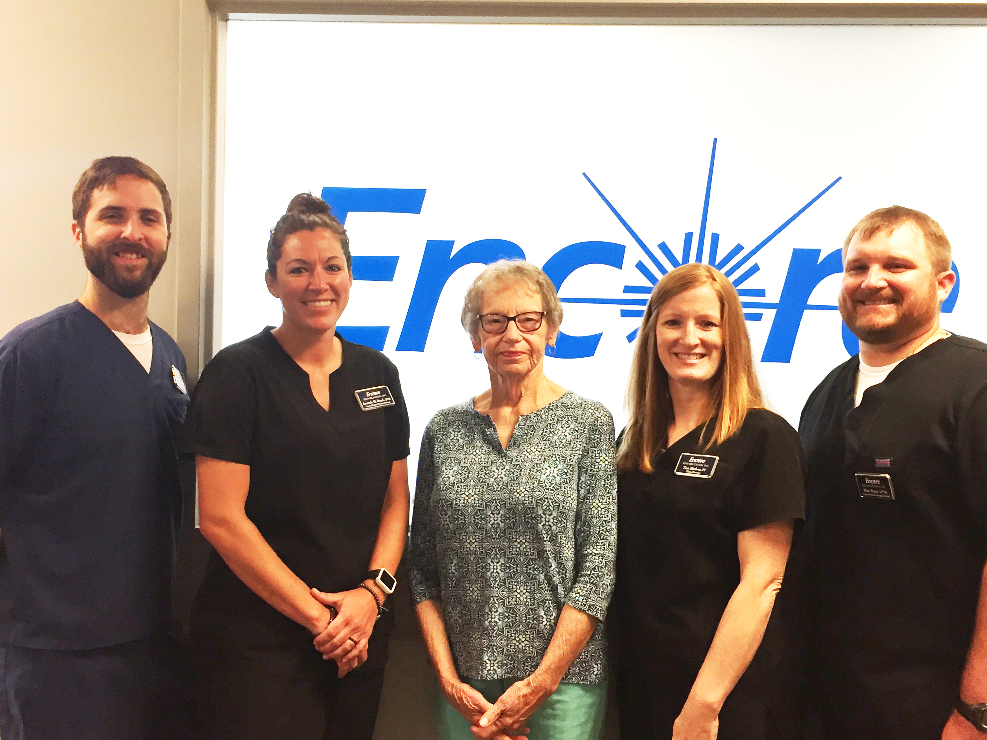 4 Encore Rehabilitation Therapists and one Patient smiling and posing for a photo