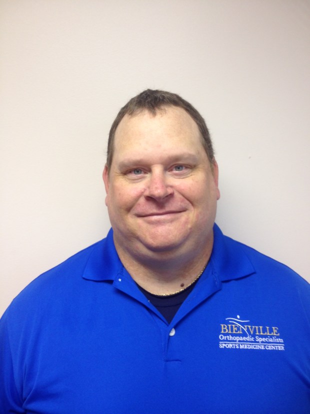 Male Athletic Trainer smiling in royal blue polo shirt