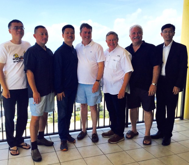 Several men posing for photo while standing on the balcony overlooking beach in southern Alabama