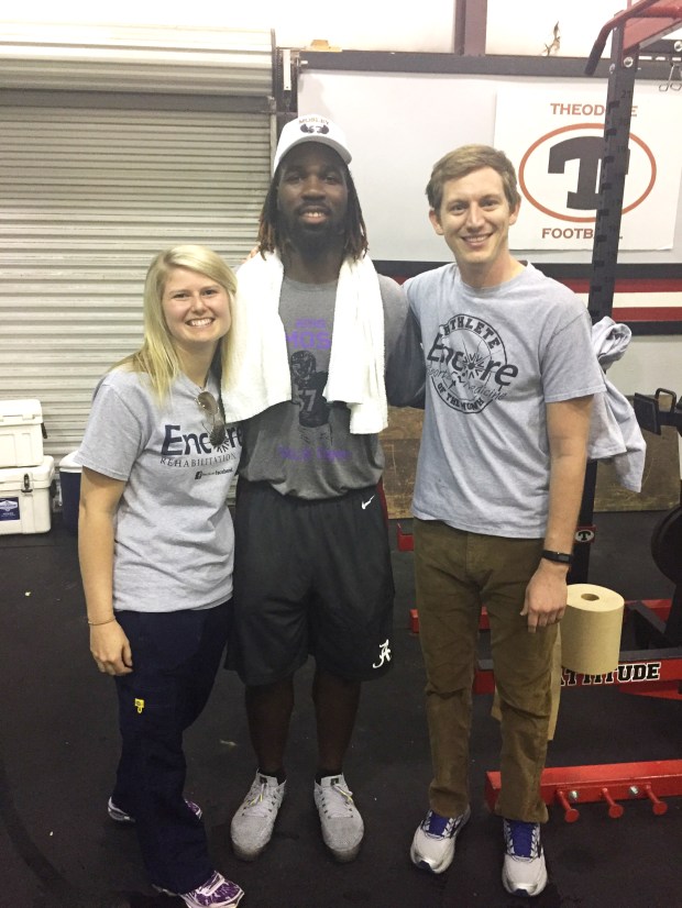 NFL Linebacker CJ Mosley posing for photo at Theodore High School (Alabama) with Encore Rehabilitation Therapists Jessie Bowles, LPTA, and Clinician Director Jack Dockery, PT