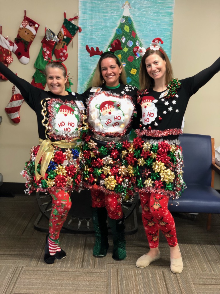 Encore Rehabilitation Therapists Susan, Jamie, and Hope prepare to compete in the "ugly sweater" contest at Andalusia Physical Therapy #EncoreRehab