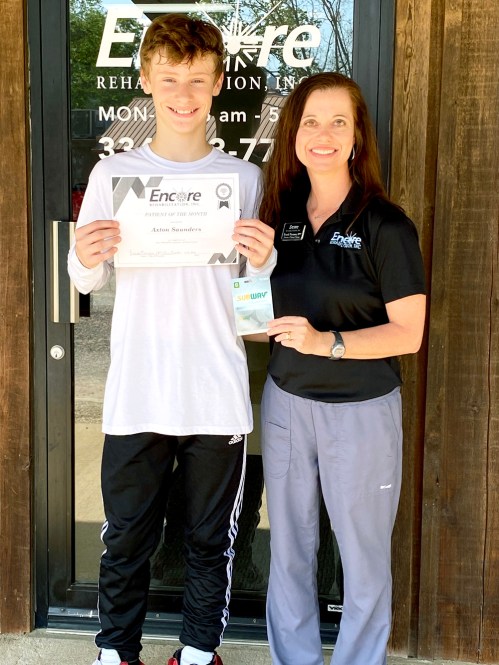 Axton is shown here with Clinic Director and Physical Therapist Brandi Norman.