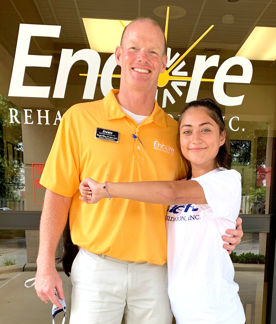 Patient of the Month Allisa Flores shows her scar from her broken elbow while she poses with #EncoreRehab Enterprise Clinic Director Randy Riley, PT