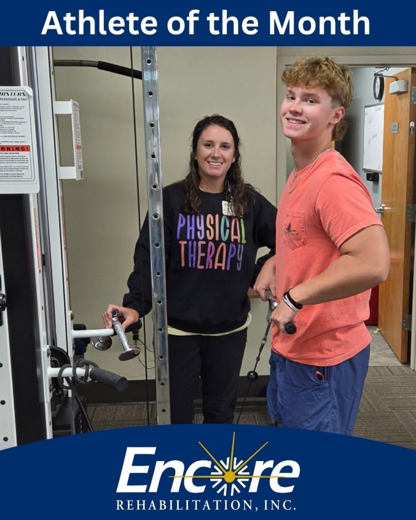 Young man using exercise equipment while his Physical Therapist looks on. Recovery from a Tommy John Surgery.  Photo inside Encore Rehabilitation-Andalusia, AL clinic