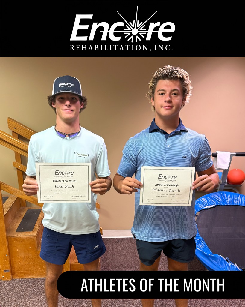 Two male athletes, John Peak and Phoenix Jarvis, standing indoors holding certificates that read 'Athlete of the Month'. They are smiling, dressed in casual athletic clothing.